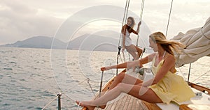 Ocean, friends and women relax on yacht for vacation in Greece, travel or summer cruise on water. Sailing, luxury and