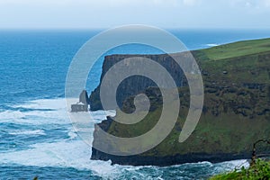 the ocean is full of bright waves and green cliffs near an ocean