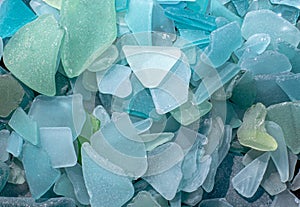 Ocean glass patterns on backgrounds with hands holding and grabbing, blues, whites, brown, green. Crafts