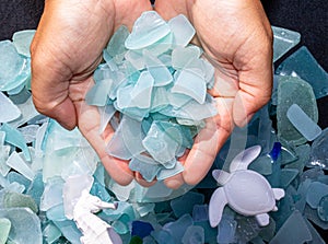 Ocean glass patterns on backgrounds with hands holding and grabbing, blues, whites, brown, green. Crafts