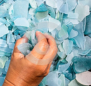 Ocean glass patterns on backgrounds with hands holding and grabbing, blues, whites, brown, green. Crafts