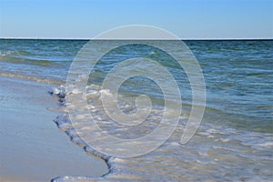 Ocean green wave, white wave foam and wet beach sand