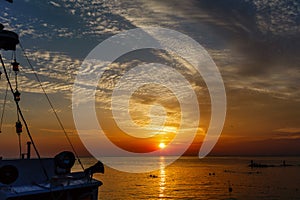 Ocean landscape at sunset. Silhouettes of fishermen and fishing