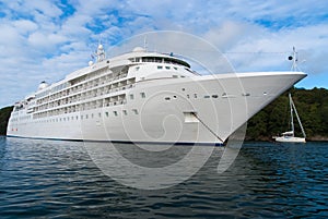 Ocean liner in sea in Fowey, United Kingdom. Cruise ship at seacoast on cloudy sky. Summer vacation on tropical island