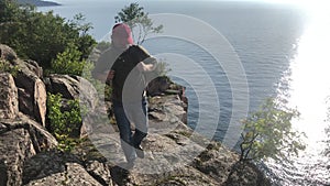 Ocean, mountain and man hiking outdoor in nature, travel for freedom or sunshine. Sea, adventure and person trekking in