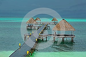 Ocean pier standing in the green emerald water with beach shed attached