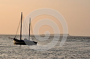 Ocean and sail boat at sunrise