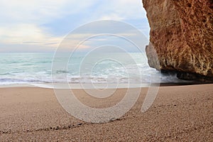 Ocean and sandy beach next to a cliff in Portugal