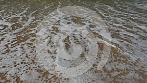 Ocean shore with sandy beach and advancing wave