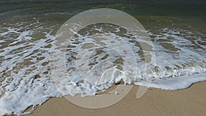 Ocean shore with sandy beach and advancing wave