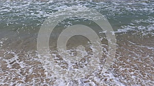 Ocean shore with sandy beach and advancing wave