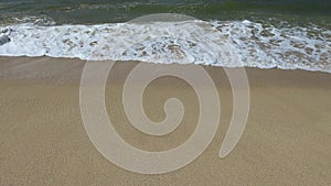 Ocean shore with sandy beach and advancing wave