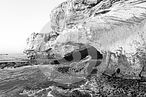 Ocean side mouth of Waenhuiskrans Cave. Monochrome