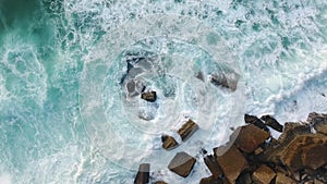 Ocean splash at rocky beach evening aerial view