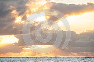 Ocean sunset with dramatic clouds and sun rays.