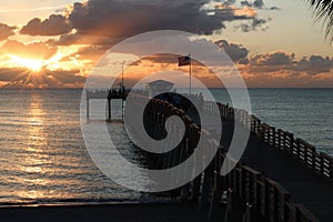 Ocean sunset with a view of a pier