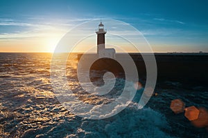 Océano surfear sobre el atlántico Costa más cercano faro durante hermoso atardecer 