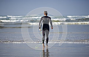 Ocean, surfing and man with surfboard at beach for waves on summer vacation, weekend and holiday by sea. Travel, nature