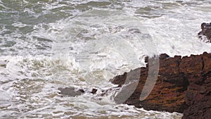 Ocean tides hitting the rocky, jagged shoreline