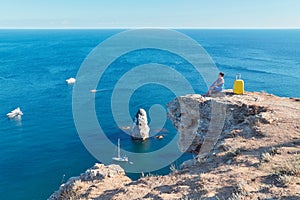 Ocean view and floating yacht in water. Lady enjoying seascape on cliff. Remote office and travel time idea, copy space