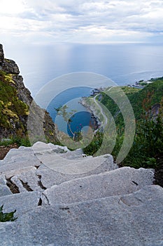 Ocean view from hiking trail to Reinebringen mountain on Lofoten islands with stairs in the foreground in portrait format