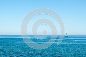 Ocean view with isolated sailboat on a sunny day