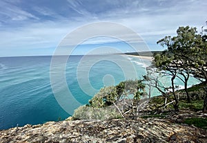 Ocean views and a surf beach taken from a rocky headland on a tropical island paradise off Queensland, Australia