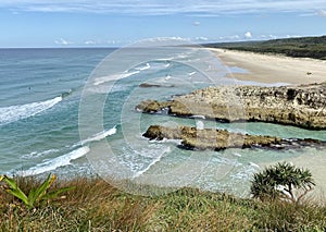 Ocean views and a surf beach taken from a rocky headland on a tropical island paradise off Queensland, Australia