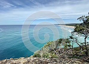 Ocean views and a surf beach taken from a rocky headland on a tropical island paradise off Queensland, Australia