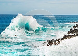 Ocean wave approaching the rock shore photo