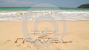 Ocean wave approaching words I love to travel written in sand on beach
