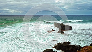 Ocean wave break at the rocky shoreline slow motion