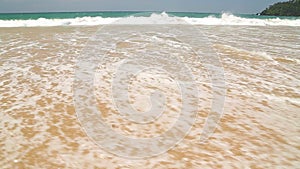 Ocean wave covering words I love to travel written in sand on beach