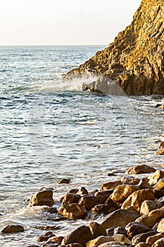 Ocean wave meeting cliff edge along rocky shoreline