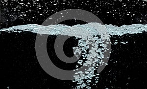 Ocean wave splash into surface underwater and many bubbles water. Drinking soda water flush air bubble. Black background isolated