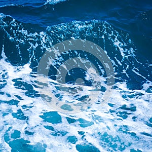 Ocean wave water sea of rippled water with white wave bubbles near the big boat on summer