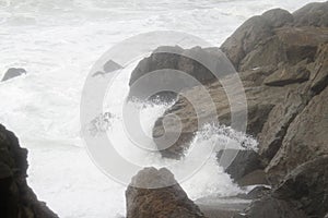 Ocean waves break over rocks