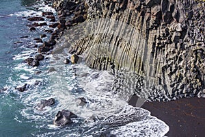 Ocean waves breaking on basalt rocks