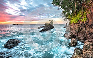 Ocean waves and coastal cliffs at sunset in Costa Rica