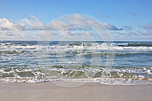 Ocean Waves crash upon the sandy beach