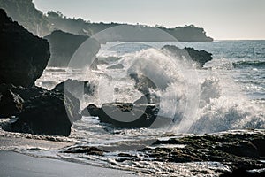 Ocean waves crashing onto the rocks in the sunset