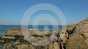 Ocean Waves Crashing On The Rocky Outcrops And Coastline - aerial pullback