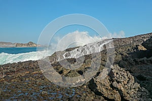 Ocean waves crashing on to lava rocks, Big Island of Lombok, Indonesia