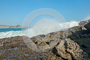 Ocean waves crashing on to lava rocks, Big Island of Lombok, Indonesia