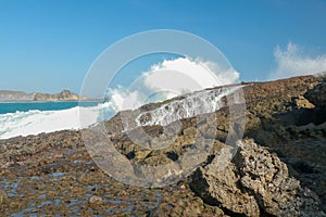 Ocean waves crashing on to lava rocks, Big Island of Lombok, Indonesia