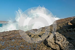 Ocean waves crashing on to lava rocks, Big Island of Lombok, Indonesia