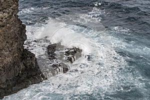 Ocean waves dashing on volcanic cliffs at Fortim do Faial, Madeira