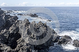 Ocean waves dashing on volcanic shore at Porto Moniz, Madeira