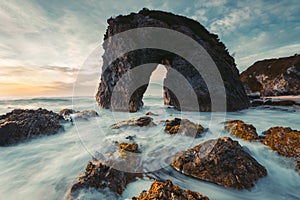 Ocean waves flow around coast and  Horse Head Rock Australia