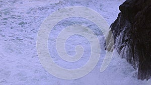 Ocean waves hitting against the rocks on a stormy day